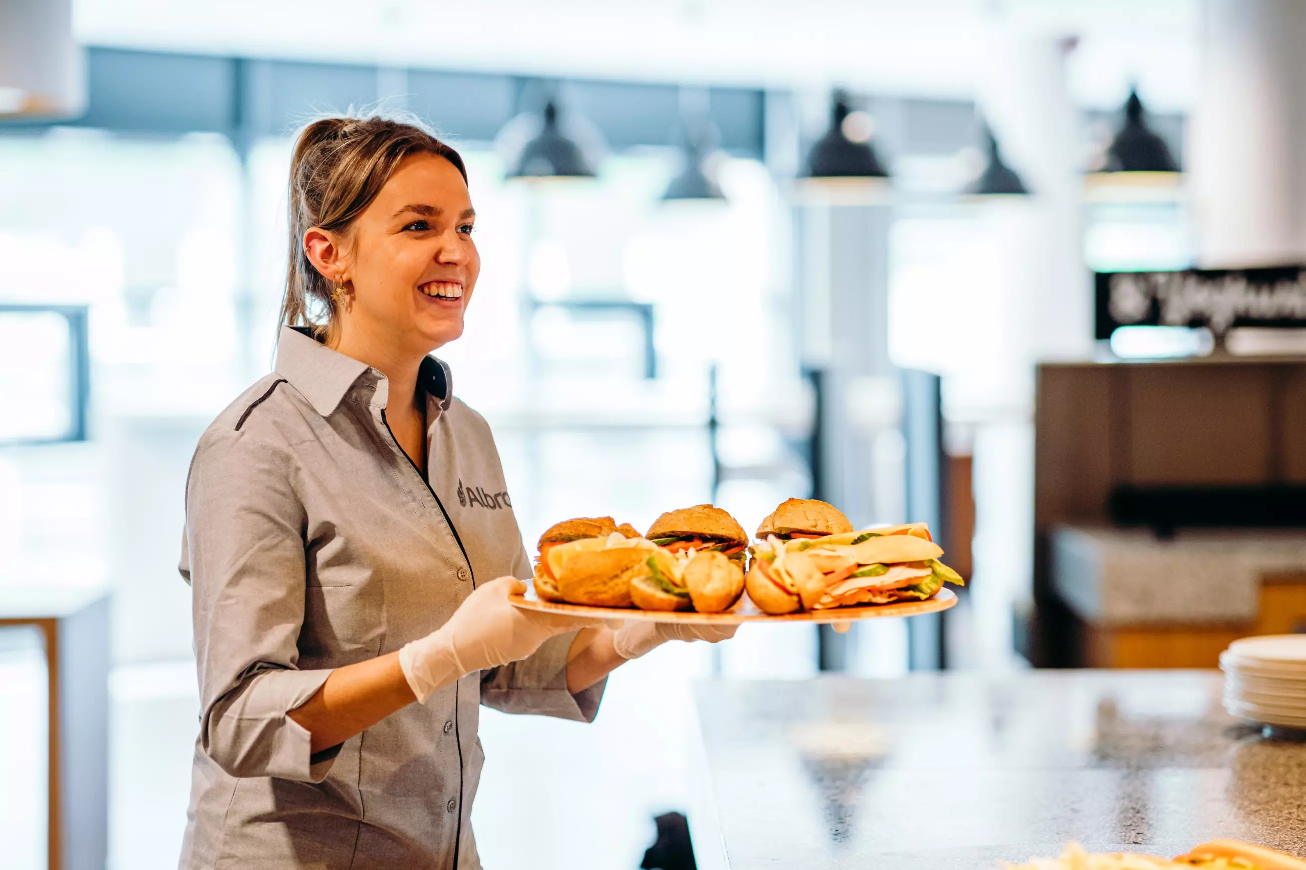 Medewerker bedrijfsrestaurants Albron met broodjes